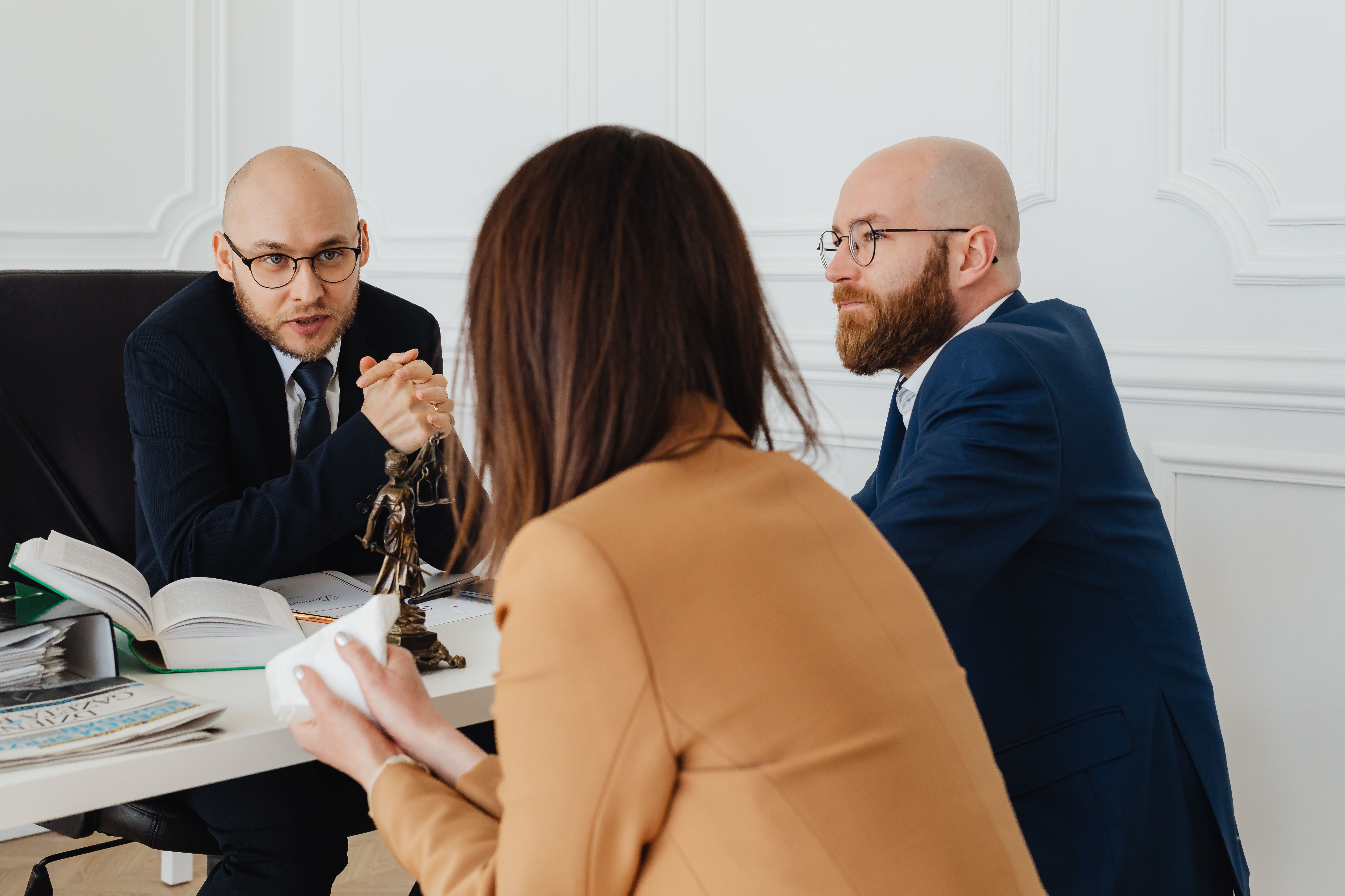 Lawyers discussing legal liability documents in a modern corporate office