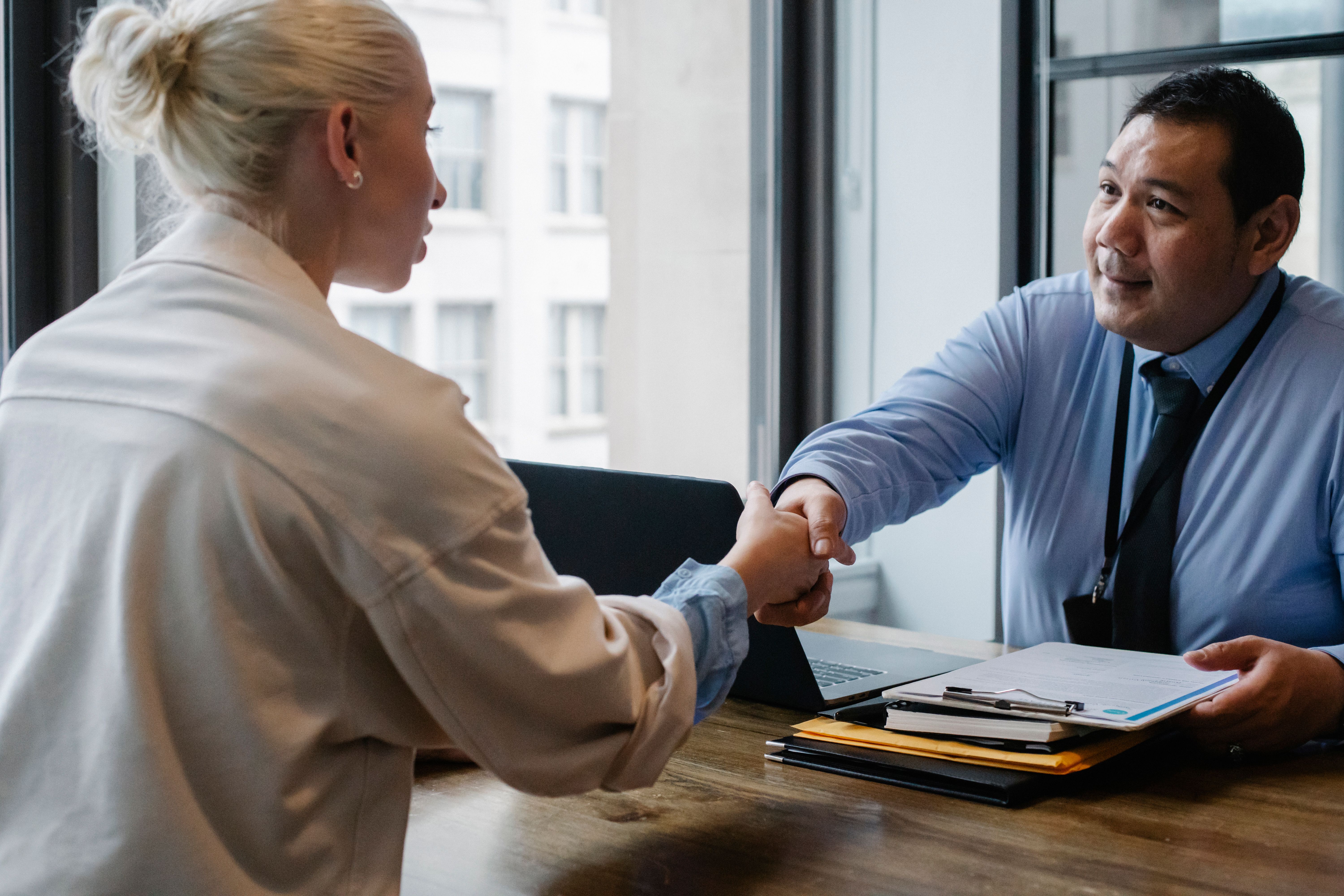 Business owner interviewing and shaking hands with a candidate before hiring an SEO consultant
