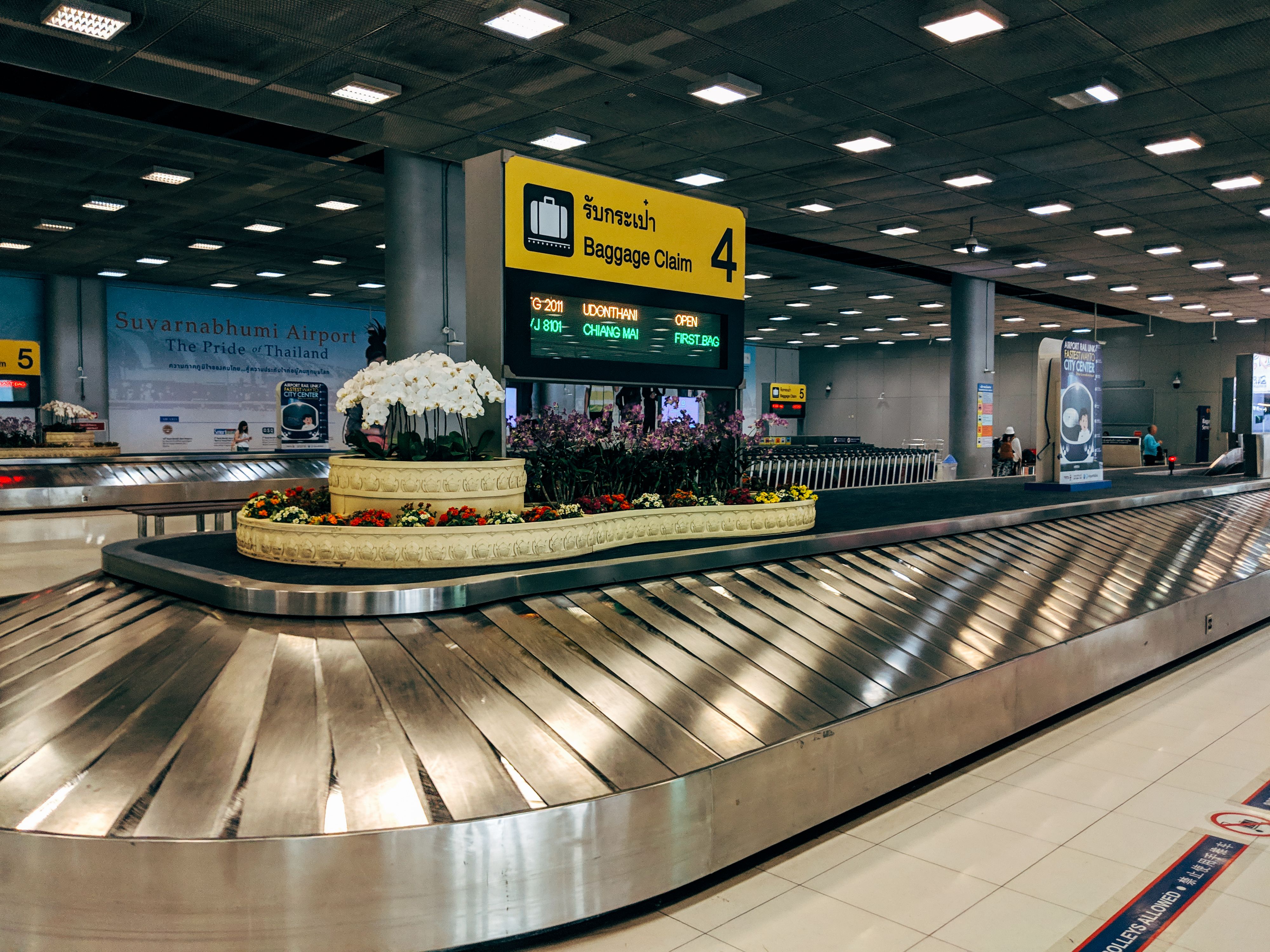 Modern airport baggage claim carousel where a business traveler's lost luggage would arrive