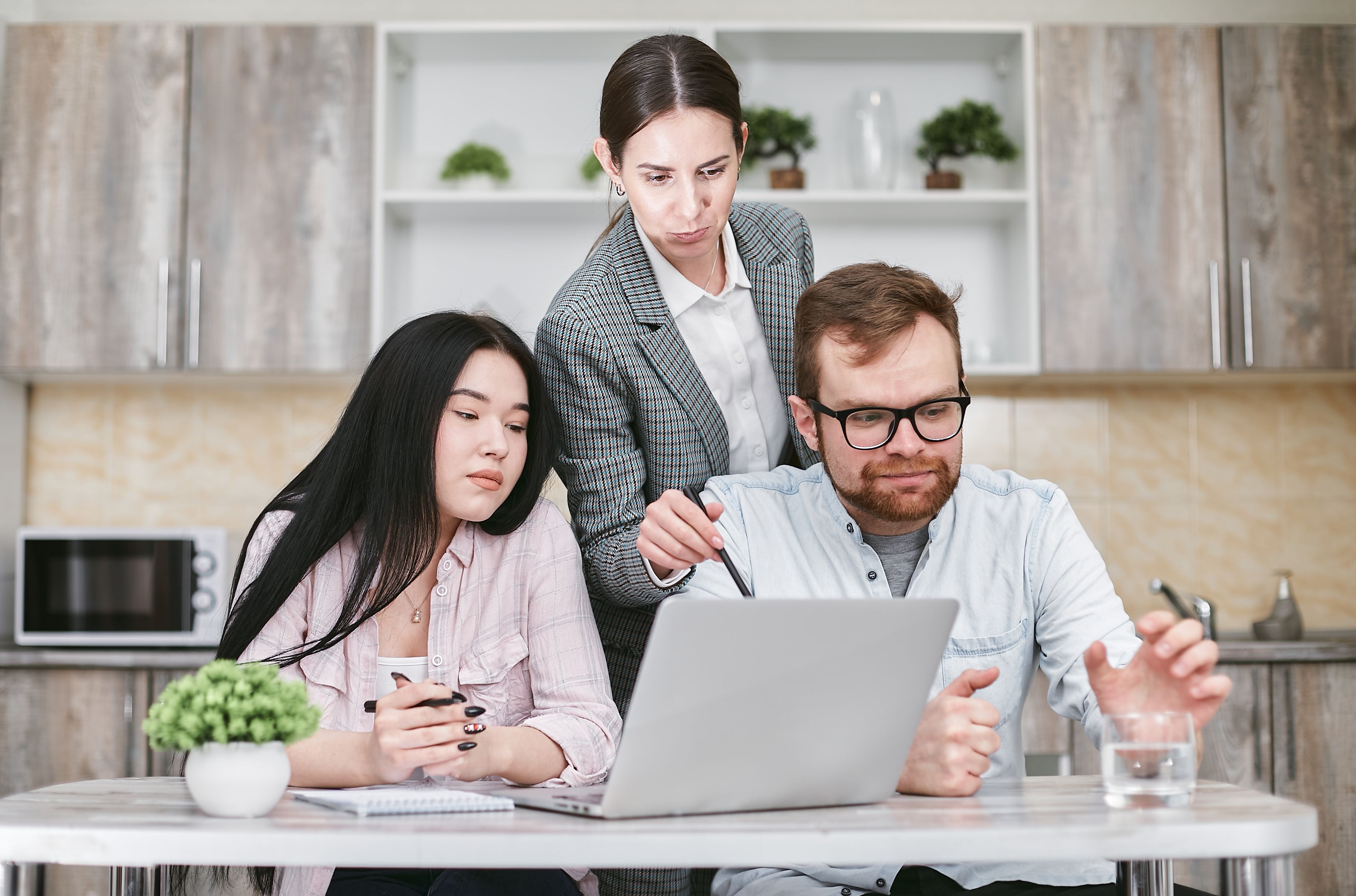 Small business team reviewing a laptop and reports during an SEO planning meeting