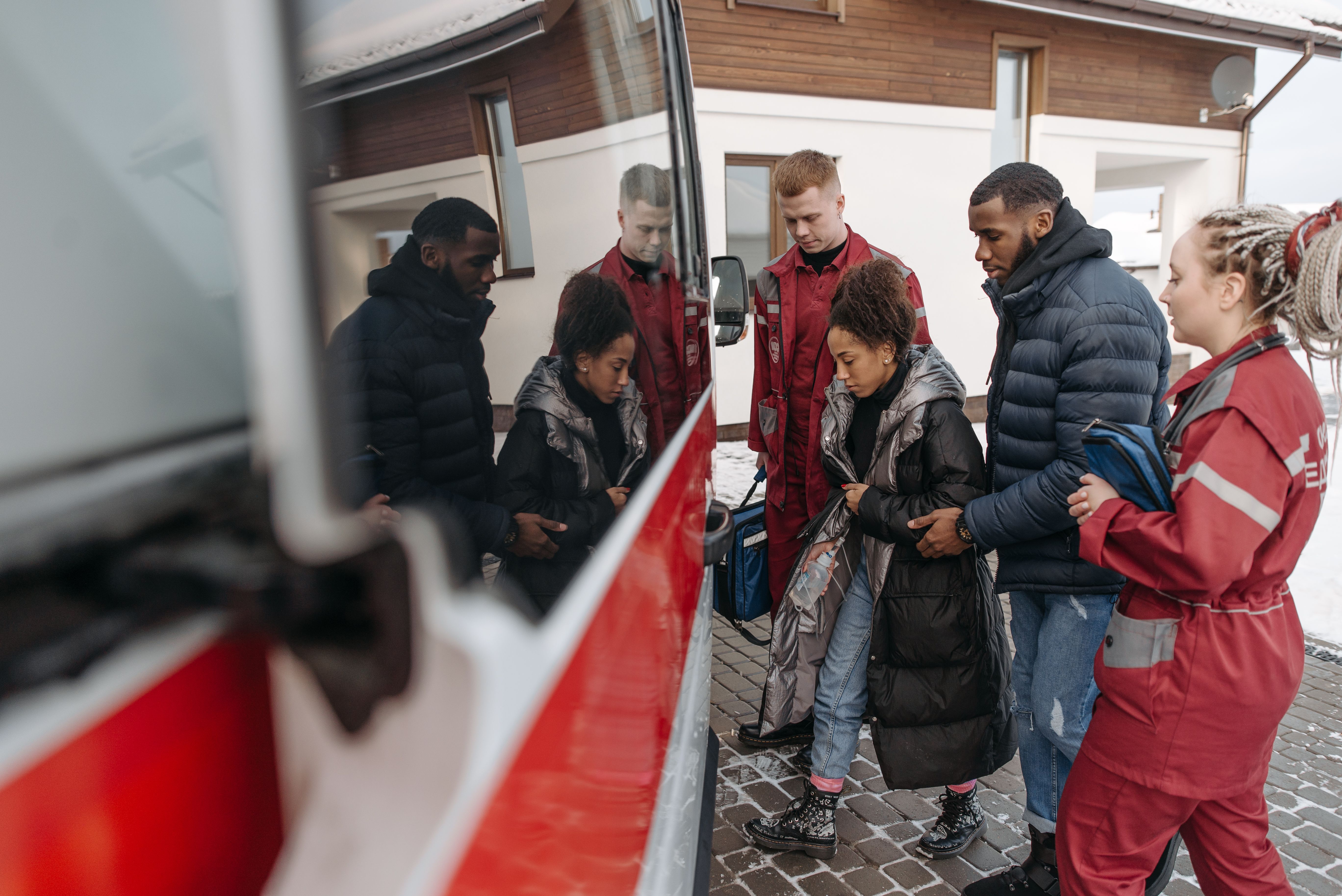 Paramedics assisting a traveler into an ambulance after a medical emergency abroad