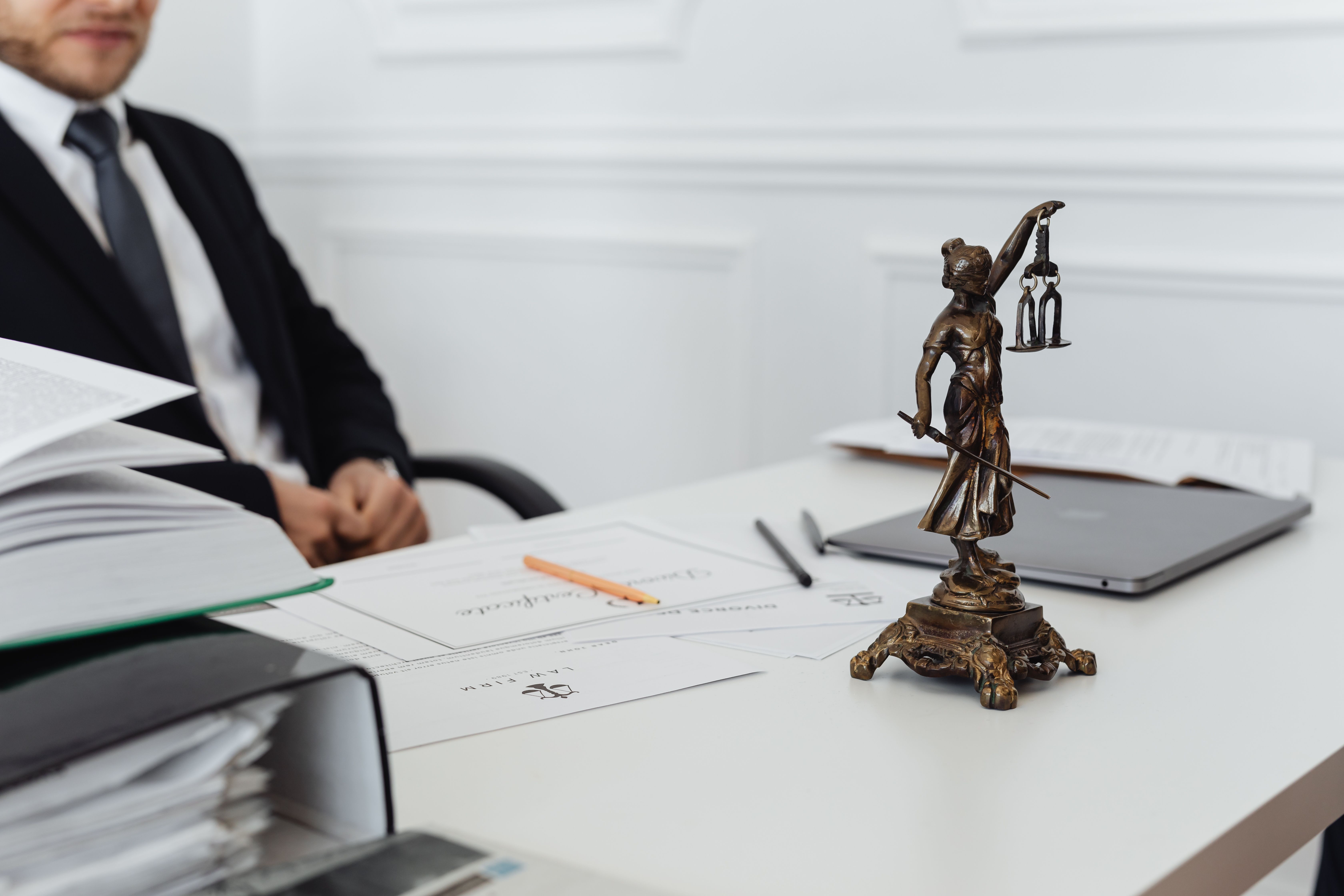 Legal workspace with documents and a Lady Justice statue